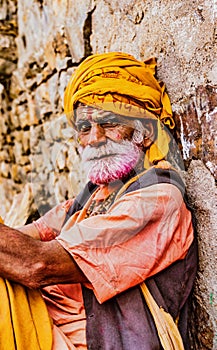 Barsana, India - February 23, 2018 - Old man with grey beard and yellow turbin rests in Holi festival