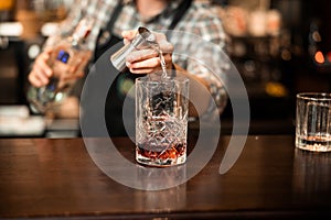 Bartender adding cocktail ingredients on whiskey cocktails