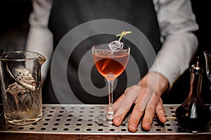 Bartender with a cocktail glass filled with summer drink