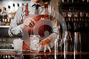 Bartender cooling out Cocktail glass mixing ice with a spoon