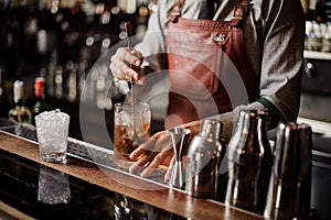 Bartender cooling out Cocktail glass mixing ice with a spoon