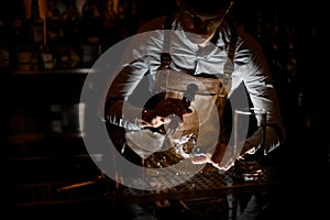 Bartender crushes the ice cube with picker