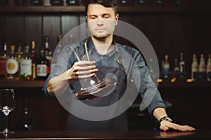 Bartender decanting wine without disturbing the sediment