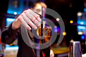 The bartender decorates slice of lemon glass of fizzy drink