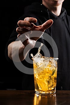 Bartender drops shot of tequila with lime into beer glass. Alcoholic cocktail Death of Mexican on black background.