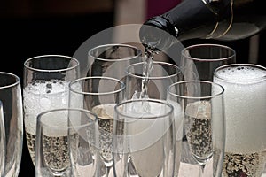 Bartender filling some glasses with champagne 