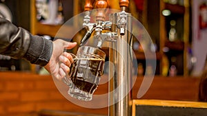 Bartender filling up with craft beer a pint glass