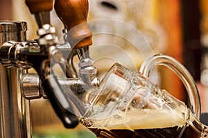 Bartender filling up a dark with craft beer a pint glass photo