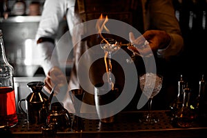 Bartender firing up alcohol in bar spoon