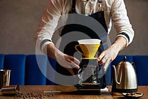 Barista pouring water on coffee ground with paper filter