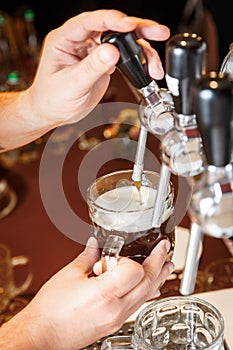 Bartender hands pouring a draught craft beer into a mug