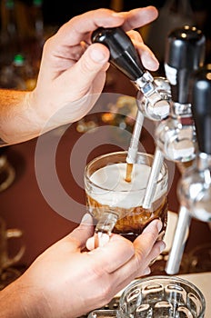 Bartender hands pouring a draught craft beer into a mug