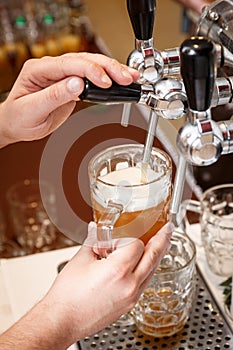 Bartender hands pouring a draught craft beer into a mug