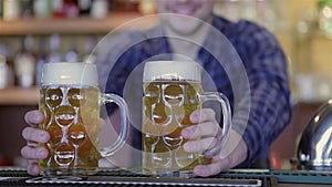Bartender holding beer glasses and smiling