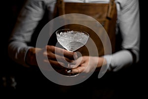 Bartender holding a cocktail glass full of crushed ice photo