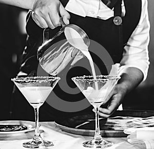 Bartender making alcohol cocktail at bar counter at nightclub, barman is making cocktail