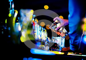 Bartender making alcohol cocktail at bar counter at nightclub, barman is making cocktail photo