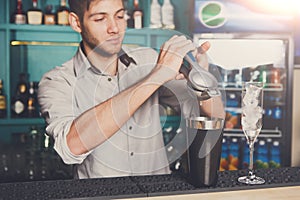 Bartender making cocktail with lime, close-up