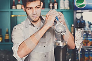 Bartender making cocktail with lime, close-up