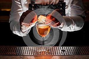 Bartender making the fresh alcoholic drink with a smoky note