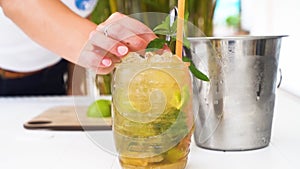 Bartender making fresh cocktail with lime juice