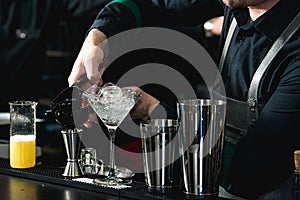 Bartender making relaxing coctail on a bar background