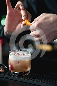 Bartender making relaxing coctail on a bar background