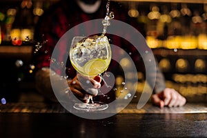 Bartender making splash of a delicious Gin Tonic cocktail with l