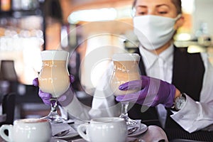 Bartender in medical mask and gloves makes latte coffee