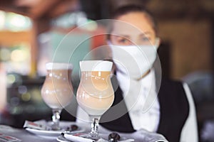 Bartender in medical mask and gloves makes latte coffee