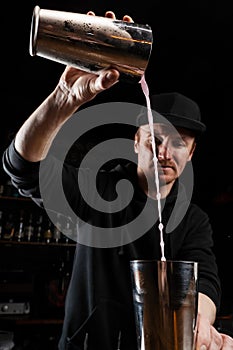 Bartender mixes egg white, lemon, dry vermouth and gin to prepare the Clover club cocktail. Barman prepares classical