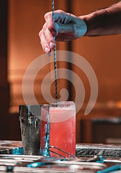 Bartender at nightclub preparing cocktails with bar equipment