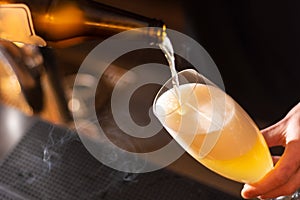 Bartender pouring the beer in the glass