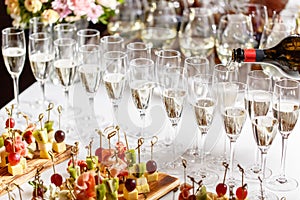 Bartender pouring champagne or wine into wine glasses on the table in restaurant. solemn wedding ceremony or happy new