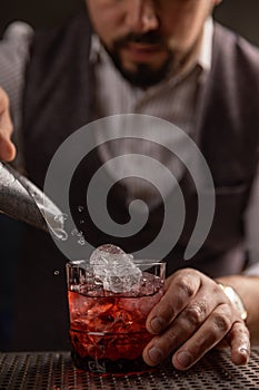 Bartender pouring cocktail at bar