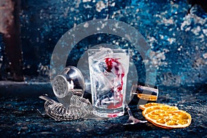 Bartender pouring cranberry juice over vodka cocktail