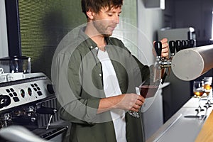 Bartender pouring fresh beer into glass