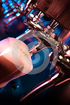 Bartender pouring a large lager beer in tap