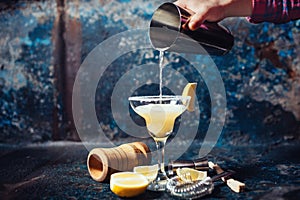 Bartender pouring lime margarita in fancy glass at restaurant photo