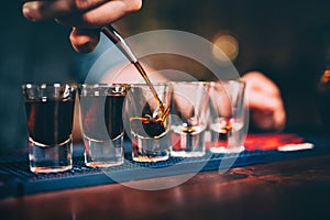 Bartender pouring and serving alcoholic drinks at bar photo