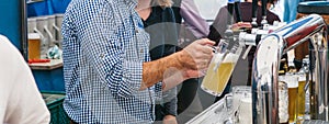 Bartender pours a beer into a mug