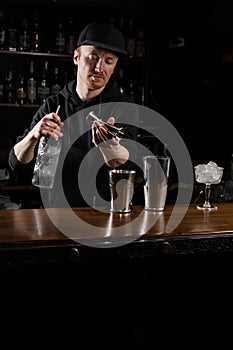 Bartender prepares classical Clover club alcoholic cocktail at the bar. Bartender mixes egg white, lemon, dry vermouth