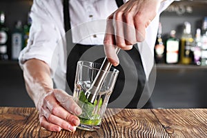 The bartender prepares a cocktail using the madler