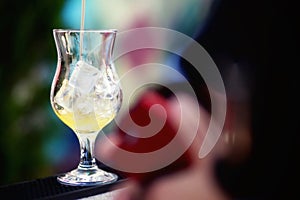 Bartender preparing a cocktail with yellow syrup