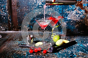 Bartender preparing cranberry juice and vodka - cosmopolitan alcoholic cocktail