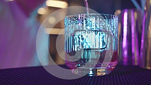 Bartender in restaurant pouring drink into glass - close up