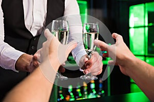 Bartender serving glass of champagne