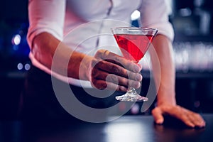 Bartender serving a red martini