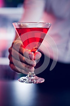 Bartender serving a red martini