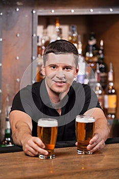 Bartender serving two glasses of beer.
